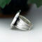 left side view, cushion black onyx gemstone bezel set bead wire and stamped cutout wire accent on tapered wide band